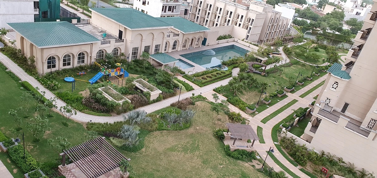 Outdoor swimming pool and clubhouse deck at ATS Triumph Sector 104