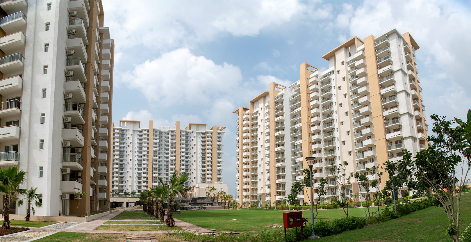 Central landscaped gardens, manicured green lawns and residential towers at Emaar Imperial Gardens Sector 102
